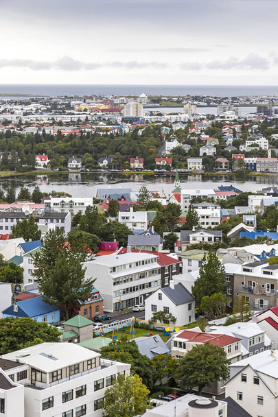 Picturesque aerial view of Reykjavik city, Iceland. Downtown, mountains and ocean scenery beyond the city. View from the top of Hallgrimskirkja Cathedral in Reykjavik - Photo, image