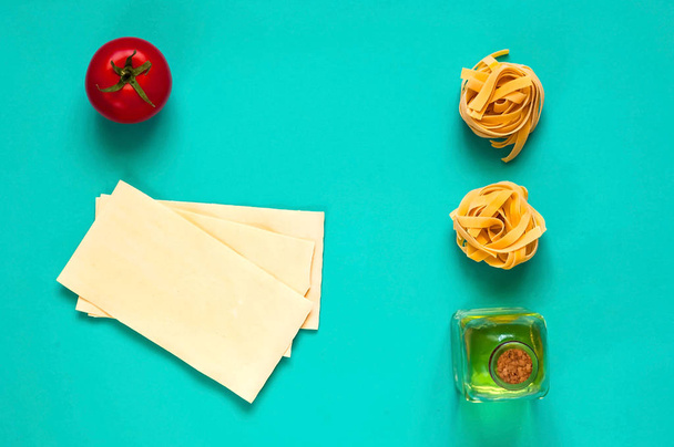 De achtergrond van het voedsel van Italiaanse Pasta. Fettuccine pasta en tagliatelle op blauwe achtergrond. Close-up, kopie ruimte.  - Foto, afbeelding
