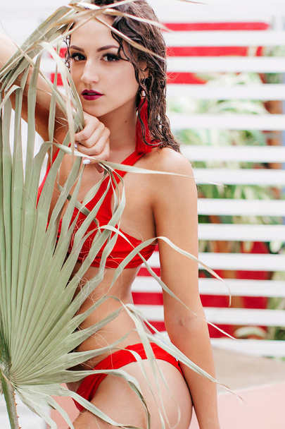 Kaunis nuori nainen punaisessa uimapuvussa poseeraa
  - Valokuva, kuva