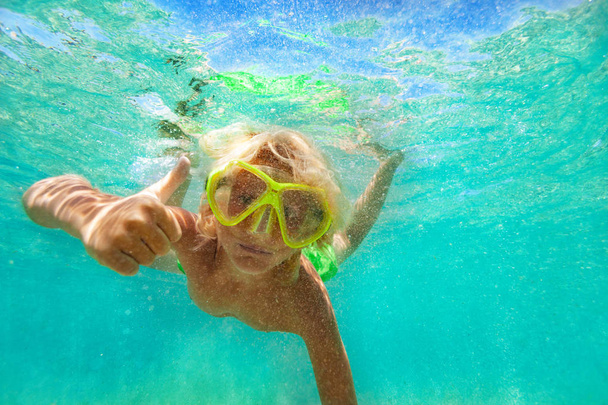 Portrait of teenage boy wearing snorkel mask swimming underwater in the sea, giving thumbs up signal - Foto, Imagem