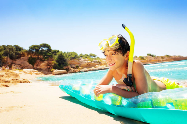 Vista laterale ritratto di adolescente che posa su materasso ad aria dopo lo snorkeling
 - Foto, immagini