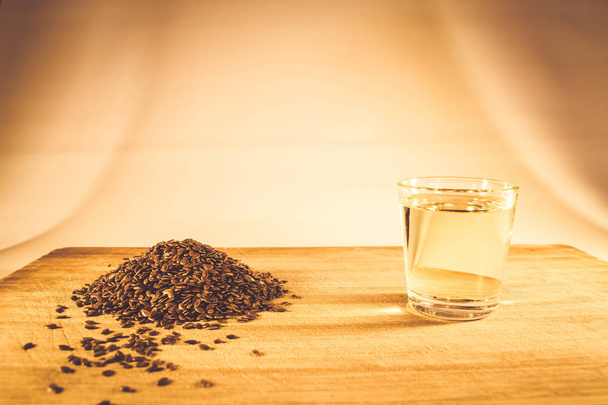 Flax seed handful, flaxseed oil in a glass on the table - Φωτογραφία, εικόνα