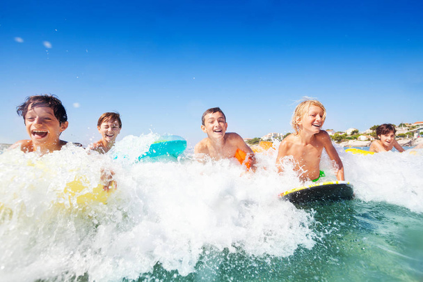 Close-up portrait of happy teenage boys riding the waves on body boards in summer - Fotografie, Obrázek