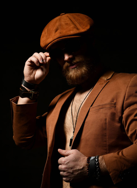 Brutal business man with beard and mustache in  brown cap and jacket  - Photo, Image