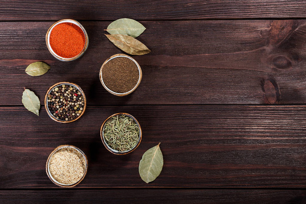 Different spices in bowls on dark wooden table - Photo, Image