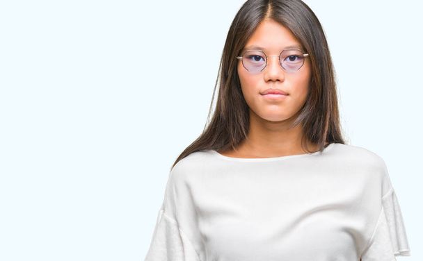 Fiatal ázsiai nő szemüveg elszigetelt háttér arcán súlyos kifejezés alatt. Egyszerű és természetes néz a kamerába. - Fotó, kép