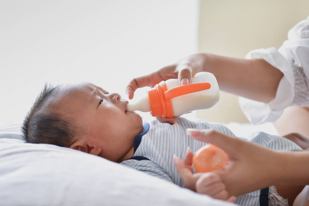 Newborn Concept. Mom is breastfeeding in the bedroom. - Photo, image