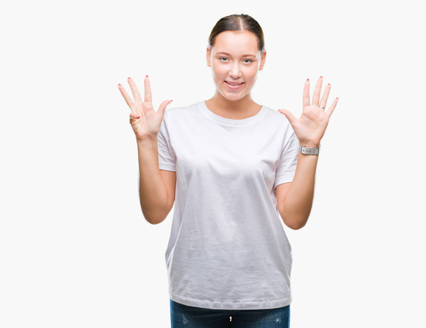 Giovane bella donna caucasica su sfondo isolato mostrando e indicando con le dita numero nove sorridendo fiducioso e felice
. - Foto, immagini
