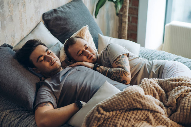 A homosexual couple on bed in studio with loft interior - Foto, immagini