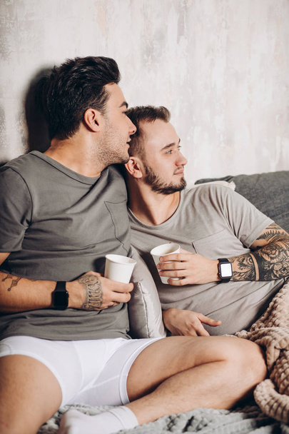 gay coppia bere latte insieme in cucina. Concetto sano - Foto, immagini