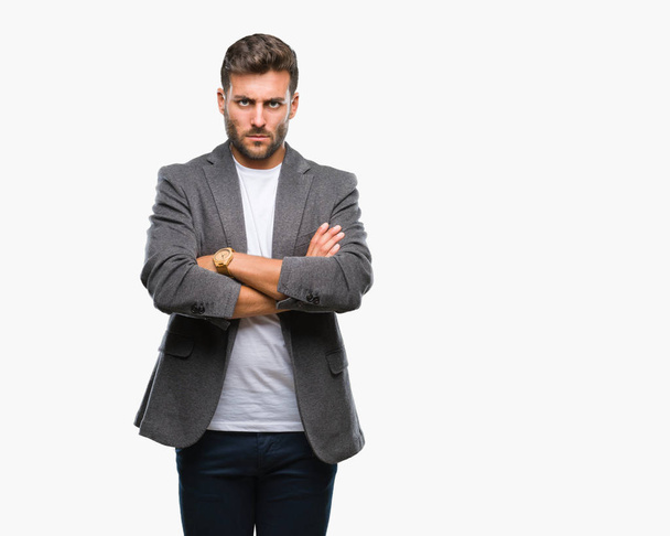 Young handsome business man over isolated background skeptic and nervous, disapproving expression on face with crossed arms. Negative person. - Fotoğraf, Görsel