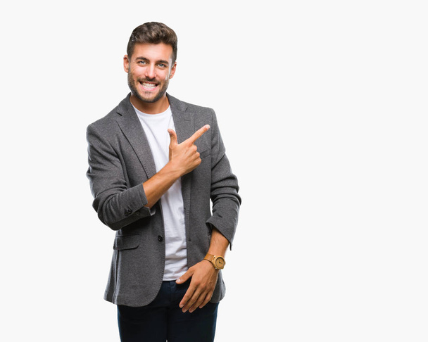 Young handsome business man over isolated background cheerful with a smile of face pointing with hand and finger up to the side with happy and natural expression on face looking at the camera. - Photo, Image