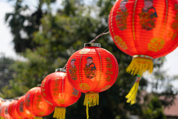 lövés a megállapodás dekoráció kínai újév & Hold-újév ünnep háttér koncepció. Kínai lámpás lógott a gyönyörű kék ég, a szabadtéri. Más nyelv átlagos gazdag vagy gazdag és boldog. - Fotó, kép