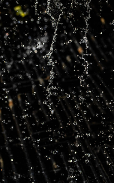 Splash Water στο σκοτάδι με μια σταγόνες του νερού που φέρουν, defocused bokeh. - Φωτογραφία, εικόνα
