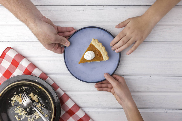 An overview of hands reaching for the last piece of pumpkin pie. - Foto, immagini