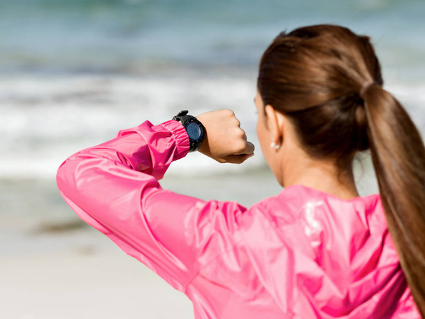 Жінка в спортивному одязі за допомогою смарт-годинника
 - Фото, зображення