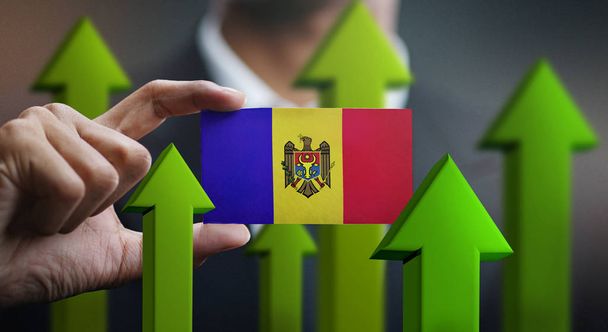 Nation Growth Concept, Green Up Arrows - Businessman Holding Card of Moldova Flag - Photo, Image