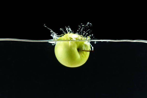 Green apple under water againsta black background  - Foto, Imagen