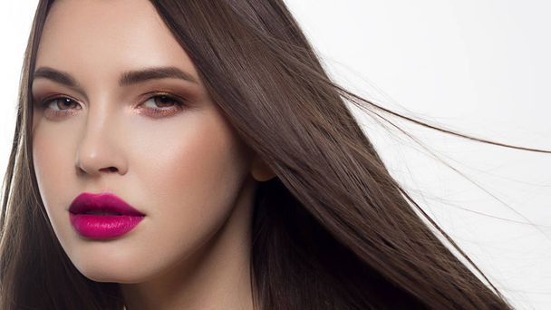 Close-up portrait of sexy european young woman model with classic glamour make-up and nude lipstick. Dark long hairstyle, christmas makeup, dark eyeshadows, natural pink lips with gloss - Photo, Image