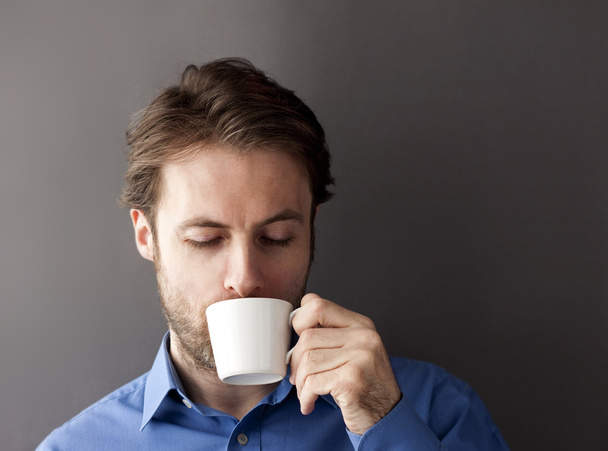 Forty years old sleepy office worker man drinking morning coffee - Foto, afbeelding