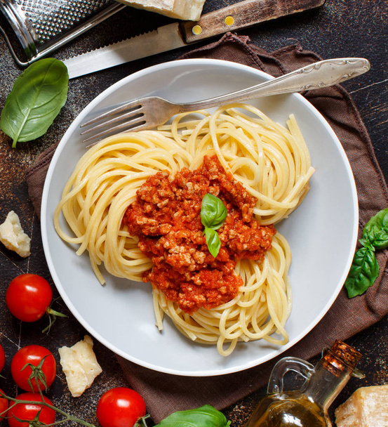 Pasta de espaguetis con salsa boloñesa en una mesa oscura vista superior
 - Foto, imagen