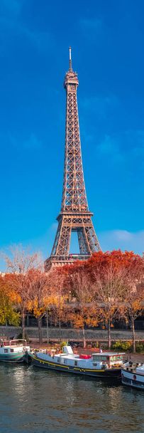 Paris, Torre Eiffel no outono, panorama com árvores vermelhas e barcos no Sena
 - Foto, Imagem