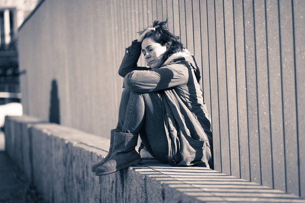 Young adult felling shame depressed and hopeless sitting alone in city urban street in Depression Loneliness Mental health Emotional pain Social violence Abusive relationship and Harassment concept. - 写真・画像