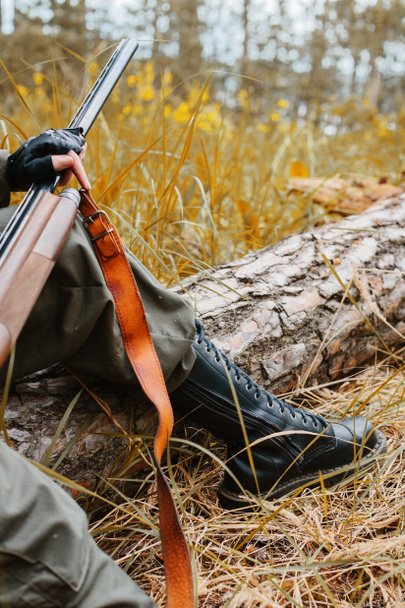 Mulher caçadora segurando uma arma na floresta
 - Foto, Imagem