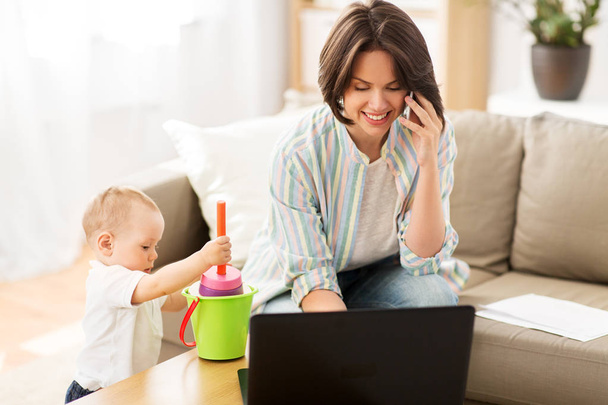 working mother with baby calling on smartphone - Zdjęcie, obraz