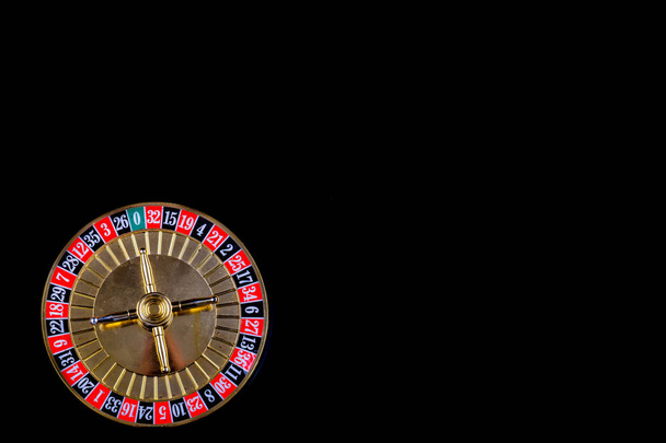 Tavolo da roulette nel casinò, con molti giochi e slot, ruota della roulette in primo piano. Sfondo nero per testo
. - Foto, immagini