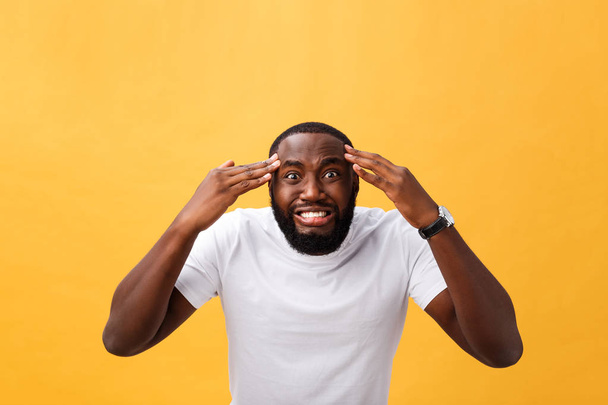 Portrait of african american man with hands raised in shock and disbelief. Isolated over yellow background - Foto, imagen