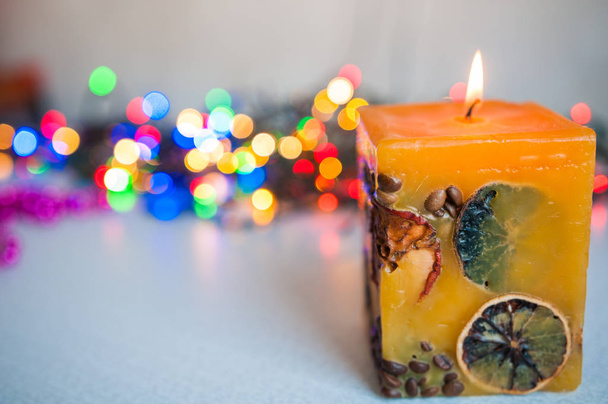 colored candle burning against the background of new year lights bokeh - Photo, Image