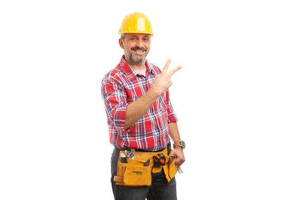 Constructeur montrant le signe numéro deux avec les doigts isolés sur fond de studio blanc
 - Photo, image