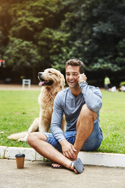 Guy with dog in park, talking on phone - Foto, Imagen