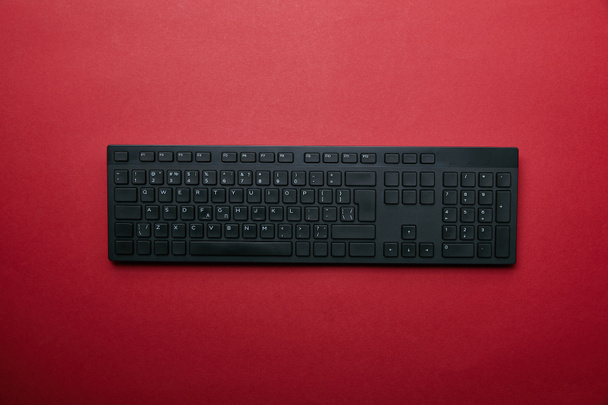 Vista superior del teclado del ordenador negro sobre fondo rojo
  - Foto, imagen