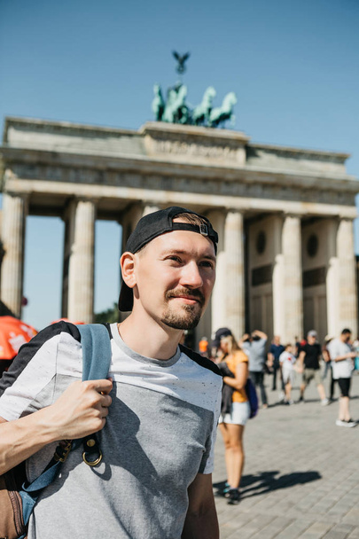 Turysta lub studentem z plecakiem w pobliżu Bramy Brandenburskiej w Berlinie w Niemczech, patrzy na zabytki. - Zdjęcie, obraz