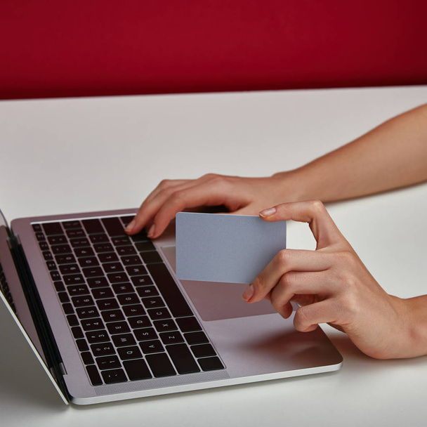 Περικοπεί προβολή της γυναίκας κρατώντας στο χέρι πιστωτική κάρτα και να χρησιμοποιούν φορητό υπολογιστή  - Φωτογραφία, εικόνα