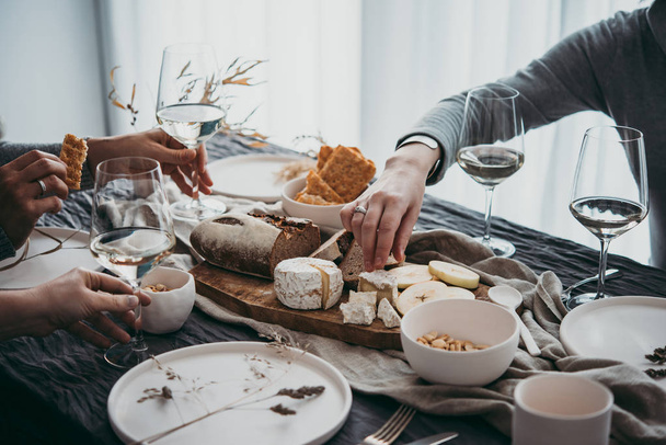 Enjoying cheese and wine at a dinner or celebration party with friends. - Foto, afbeelding