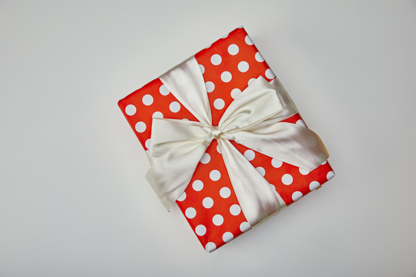 Draufsicht auf verpacktes Geschenk mit Schleife isoliert auf grauem Hintergrund  - Foto, Bild