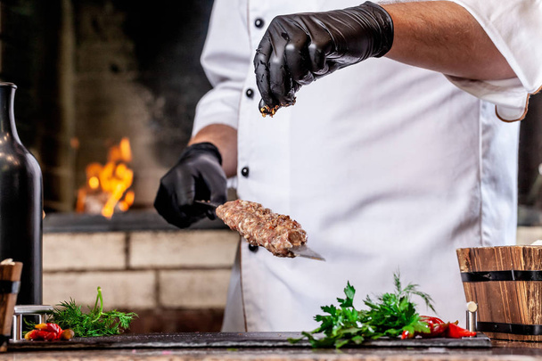 The concept of Georgian cuisine. Recipe for cooking meat lyulya kebab in the dough on the grill. Chef puts meat on a skewer. - Foto, Imagem