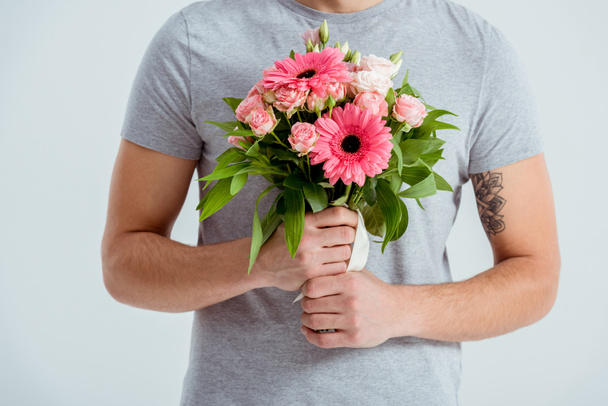 cropped view of man holding pink flower bouquet isolated on grey - Foto, afbeelding