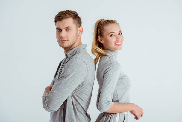 serious man and beautiful smiling woman posing together isolated on grey - Photo, Image