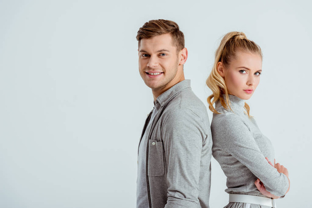 serious woman and handsome smiling man posing together isolated on grey - Foto, Bild
