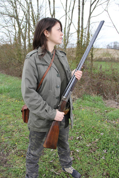 vrolijke jonge vrouw hunter holding haar pistool close-up - Foto, afbeelding