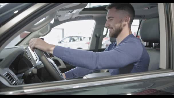 Pohledný muž s bradkou v dobré auto a zobrazeno klíč.  - Záběry, video