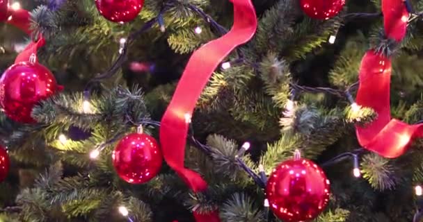 Kerstverlichting - verticale slowmotion op de decoratie, verlichting, linten en rode ballen, kerstboom. Decoraties, versierde kerstboom. - Video