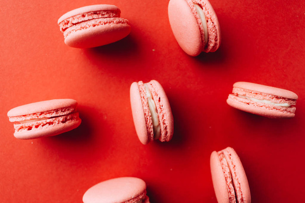 pattern of delicious pink macaroons on red table sweet dessert  - Fotó, kép