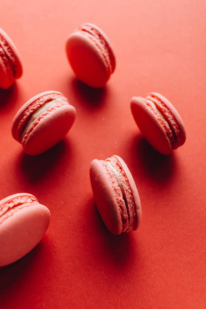 composition of delicious pink macaroons on red table sweet dessert  - Fotografie, Obrázek