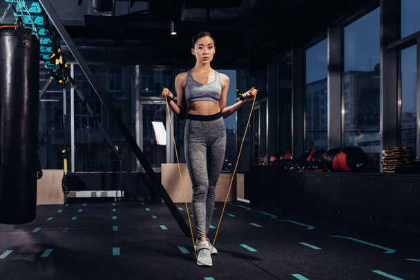 athletic girl exercising with jump rope at gym - Foto, Bild
