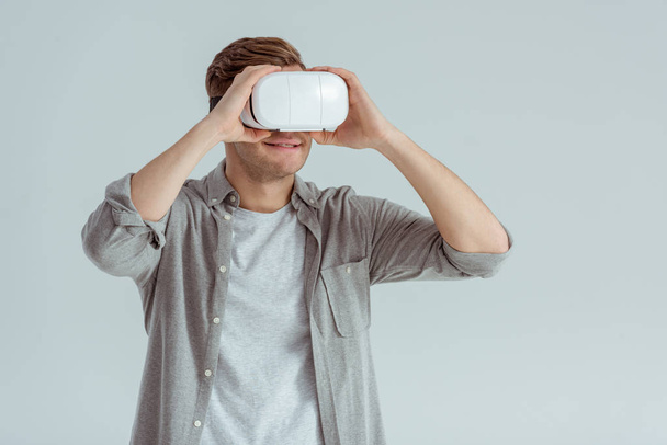 smiling man wearing virtual reality headset isolated on grey - 写真・画像